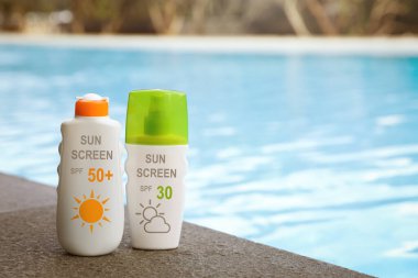 Güneş kremleri havuz kenarında şişelerde. Güneş koruma ürünü