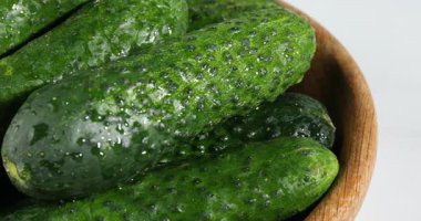 Beyaz masadaki ıslak salatalıklar, yakın plan, kamera hareket ediyor.