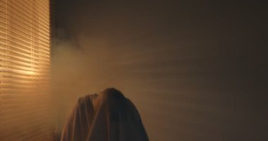 Ürkütücü hayalet. Beyaz çarşaflı adam içeride duman içinde.
