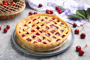 Gri desenli masada vişneli turta ve böğürtlen. Yakın plan.