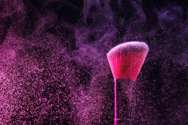 Siyah arka planda pembe göz farlı makyaj fırçası, yakın plan.