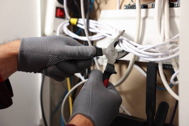 İçerde penseyle ısıtma kaloriferini tamir eden adam, yakın plan.