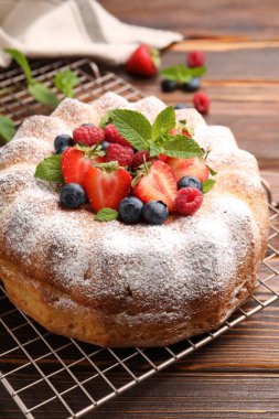 Tahta masada pudra şekeri ve böğürtlenli Lezzetli kek, yakın plan.