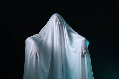 Ürkütücü hayalet. Siyah arka planda beyaz çarşaflı adam