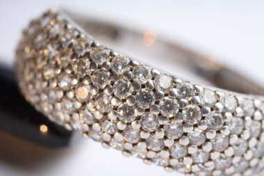 Işıklı arka planda parlak elmasları olan güzel bir yüzük, makro manzara.