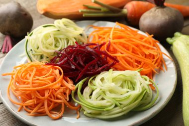 Ahşap masada farklı erişte ve sebzeler, yakın plan.