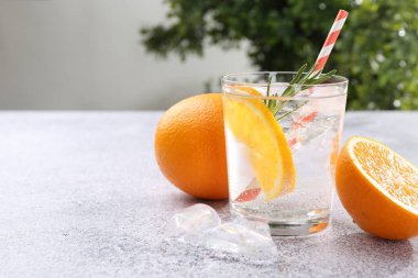 Portakal dilimli soda ve gri masada biberiye, yakın plan. Metin için boşluk