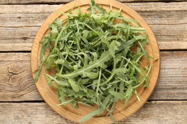 Taze yeşil roka yaprakları ahşap masanın üstünde, üst tarafta.