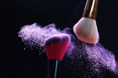 Siyah arka planda mor göz farlı makyaj fırçaları, yakın plan