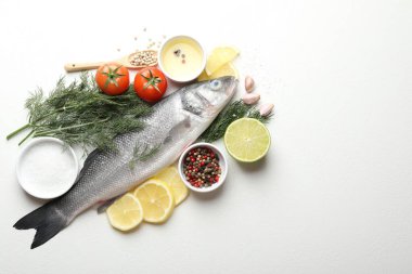 Beyaz masadaki baharatlı taze çiğ deniz kabuğu balığı, yazı için düzlük ve boşluk. Deniz ürünleri lezzetleri.