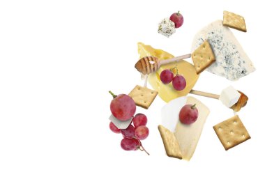 Peynir ürünleri beyaz arka planda havada. Farklı peynir, üzüm, kraker ve bal çeşitleri.