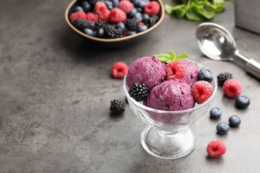 Taze böğürtlenli lezzetli şerbet ve tatlı kasesinde nane şekeri. Gri desenli masa, yakın plan.