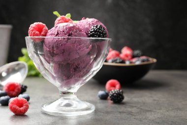 Taze böğürtlenli lezzetli şerbet ve tatlı kasesinde nane. Gri desenli masa, koyu arkaplanlı, yakın plan.