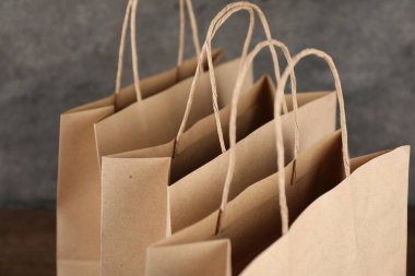 Bulanık arkaplanda Kraft kağıt torbaları, yakın plan.