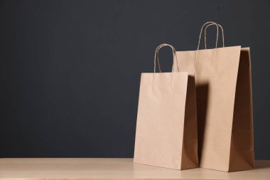 Kravat kâğıdı torbaları ahşap masanın üzerinde, karanlık arka plana karşı, yakın plan. Metin için boşluk