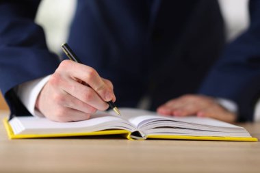 Masada kalemle deftere yazan adam, kapat