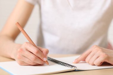 Not defterine kalemle yazı yazan kadın, yakın plan