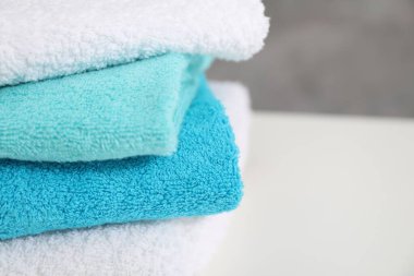 Beyaz masadaki renkli havlular yığını, yakın plan. Metin için boşluk