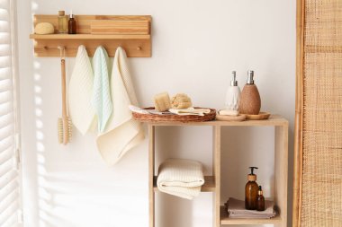 Temiz waffle havluları kancada asılı, fırça ve spa ürünleri banyoda