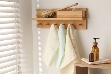 Temiz waffle havluları kancada asılı, fırça ve spa ürünleri banyoda