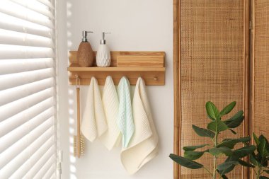 Temiz waffle havluları ve banyoda askıda asılı fırça.