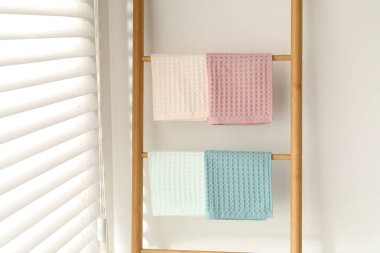 Beyaz duvarın yanındaki raflarda asılı duran temiz waffle havluları.