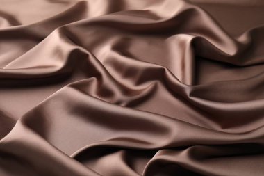 Arkaplan olarak buruşuk açık kahverengi ipek kumaş, yakın plan