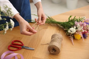Çiçek buketi yapan bir çiçekçi ahşap masa, kapalı, yakın çekim