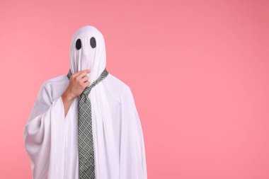 Pembe arka planda kravatlı hayalet kostümlü bir adam. Metin için boşluk