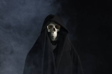 Ürkütücü hayalet. Siyah arka planda dumanla kaplı iskelet