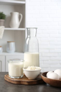 Mutfaktaki gri desenli masada farklı süt ürünleri ve yumurtalar.