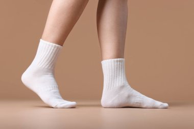 Bej arka planda beyaz çoraplı kadın, yakın plan.