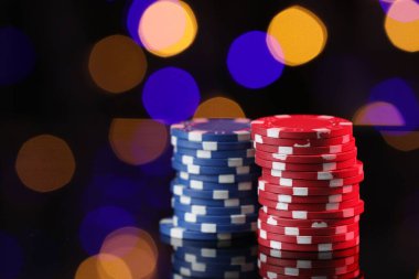 Ayna yüzeyindeki kumarhane çipleri bulanık ışıklara karşı, yakın plan. Metin için boşluk