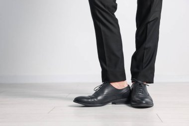 Kapalı mekanda siyah deri ayakkabı giyen bir adam, yakın plan. Metin için boşluk