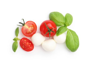 Lezzetli mozzarella peynirli toplar, domates ve fesleğen beyaza izole edilmiş.