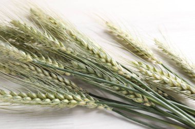 Açık ahşap masada bir sürü yeşil buğday çivisi var.