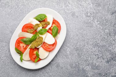 Peynirli Caprese salatası, domates, fesleğen ve pesto sosu. Metin için boşluk