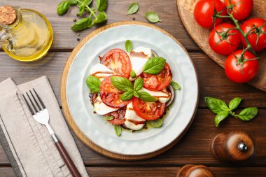 Caprese salatası ahşap masada balzamik sirkeyle servis edilir.