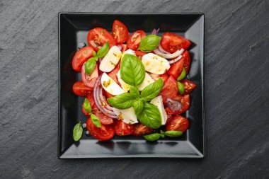 Mozarella, domates, fesleğen, soğan ve baharatlı Caprese salatası.