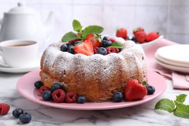 Beyaz mermer masada pudra şekeri ve böğürtlenli Lezzetli kek, yakın plan.