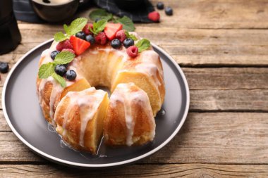 Lezzetli kek parçaları, böğürtlenli, jöleli ve naneli ahşap masa, yakın plan.