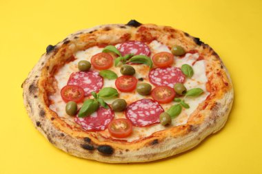 Salamlı, zeytinli, domatesli ve fesleğenli lezzetli pizza.