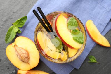 Buzlu şeftali çayını serinletiyor, gri masada, düz yerde.