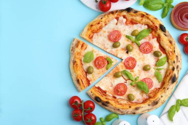Açık mavi arka planda leziz pizza ve malzemeler. Metin için boşluk