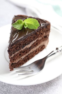 Gri masadaki çatal ve naneli çikolatalı kek, yakın plan.