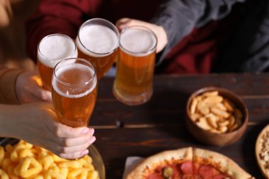 Bira ve atıştırmalık arkadaşlarla ahşap masada, yakın plan