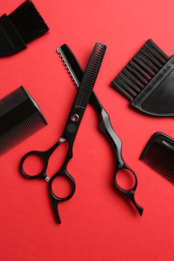 Kırmızı arka planda farklı kuaför aletleri, düz yatıyordu