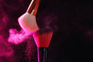 Siyah arka planda pembe göz farlı makyaj fırçaları, yakın plan