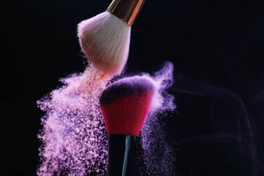 Siyah arkaplanda renkli göz gölgeli makyaj fırçaları, yakın plan