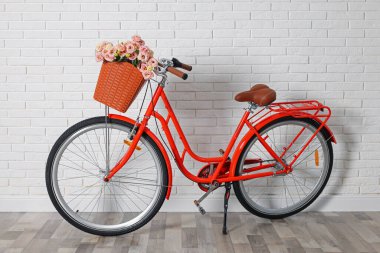 Beyaz tuğla duvarın yanında bir sepet güzel çiçekli bisiklet.